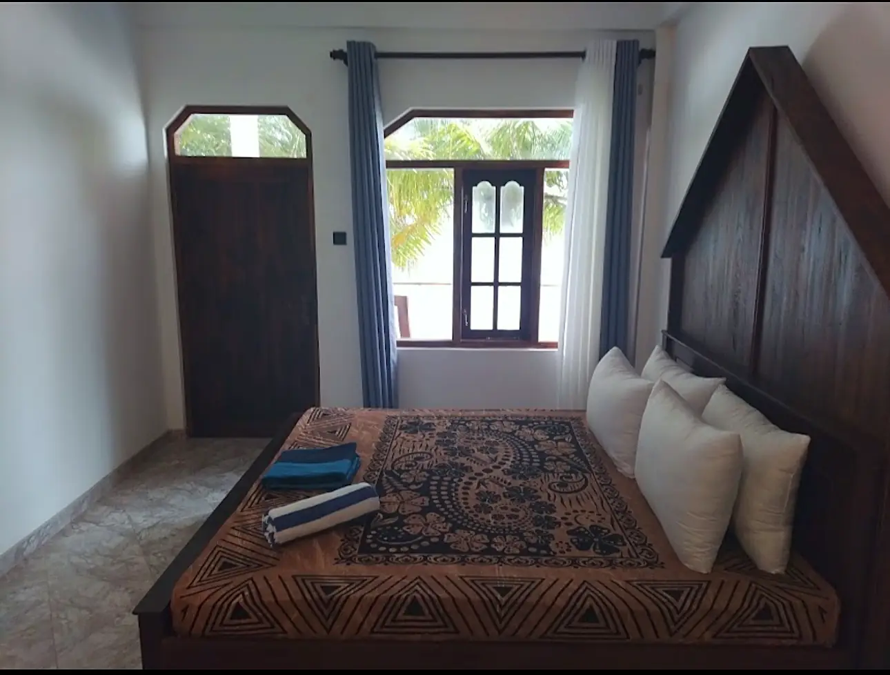 Guest room with balcony doors opening onto coconut palms at CanRoyal Resort, Tangalle